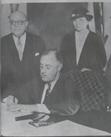 Sen. Robert Wagner and Sec. of Labor Frances Perkins watch President Roosevelt sign the National Labor Relations Act